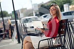 Businesswoman sitting on bench looking at camera