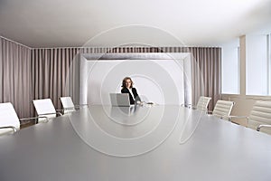 Businesswoman Sitting In Boardroom With Laptop