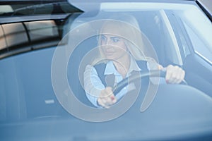 Businesswoman sitting in drivers seat in her car