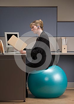 Businesswoman sitting on exercise ball