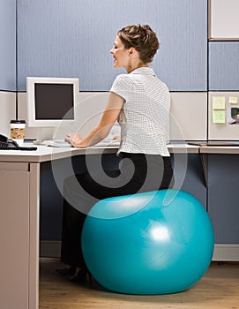 Businesswoman sitting on exercise ball at desk photo