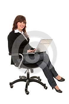 Businesswoman sitting in office chair with laptop