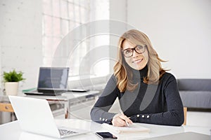 Businesswoman sitting at office desk and doing some paperwork