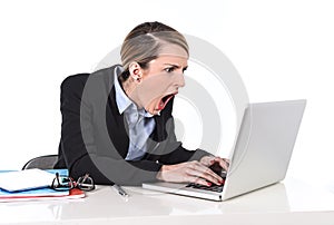 Businesswoman sitting at office desk working with laptop in stress looking upset