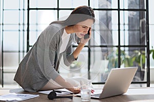 Businesswoman with phone in modern office talking photo