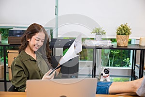 businesswoman sitting relaxing reclining with feet up on computer desk reading