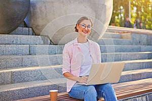 Businesswoman sitting stairs summer park using laptop Business persone working remote. Outdoor photo
