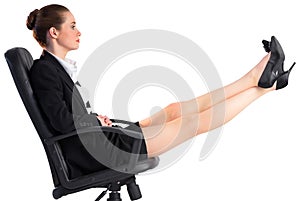 Businesswoman sitting on swivel chair with feet up photo