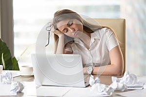 Businesswoman sleeping with head on hand at work photo