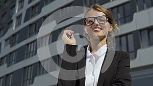Businesswoman in smart suit putting on glasses