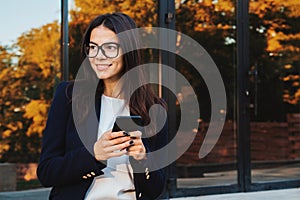 Businesswoman with smartphone. Student girl using cell phone. Beautiful woman in glasses surfing internet on mobile