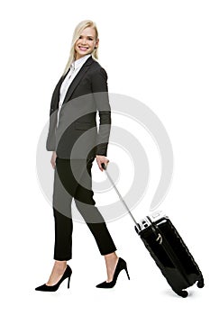 Businesswoman smiling and carrying a suitcase