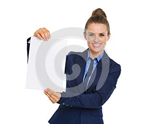 Businesswoman smiling and holding up a blank piece of paper