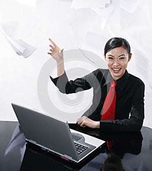 Businesswoman smiling while throwing papers