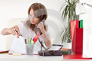 Businesswoman speaks by phone at the office.