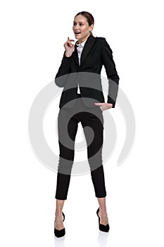 Businesswoman standing with hand in pocket and figuring something out photo