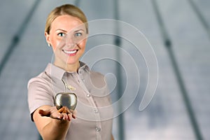 Businesswoman standing and holding golden apple in her hand.