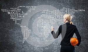 Businesswoman standing near world map on wall