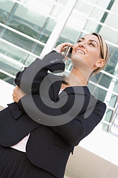 Businesswoman standing outdoors using mobile phone