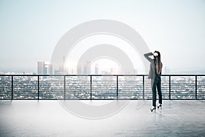 Businesswoman standing on roofrop with panoramic city view