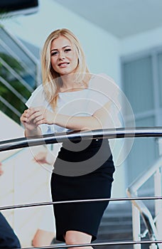 Businesswoman standing on the stairs in office.