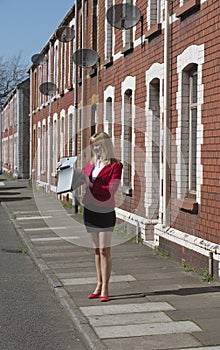 Businesswoman standing in street looking at briefcase