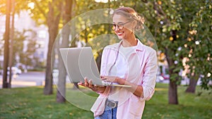 Businesswoman standing summer park using laptop Business persone working remote. Outdoor