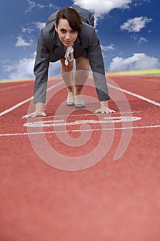 Businesswoman on start line of a running track