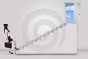 Businesswoman stepping up ladder to success door 1