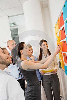 Businesswoman Sticking Labels On Whiteboard