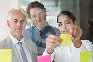 Businesswoman sticking sticky notes