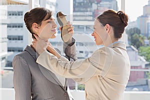 Businesswoman strangling another who is defending with her shoe