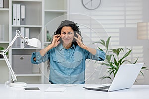 Businesswoman stressed by noise in a modern office setting