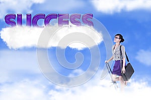 Businesswoman with success word over the cloud