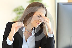 Businesswoman suffering eyestrain at office