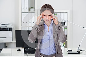 Businesswoman Suffering From Headache In Office