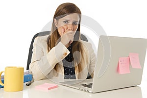 Businesswoman suffering stress at office computer desk looking worried depressed and overwhelmed