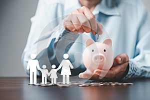Businesswoman take a position to protect on the piggybank and paper family in hand, donation, saving, charity, family finance plan