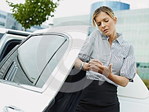 Businesswoman Takes Notes On Palm Of Hand During Phone Call