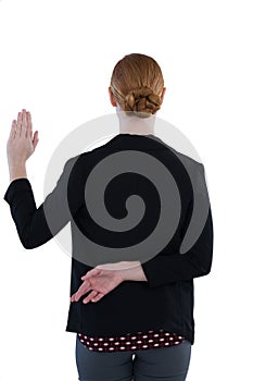 Businesswoman taking oath with fingers crossed