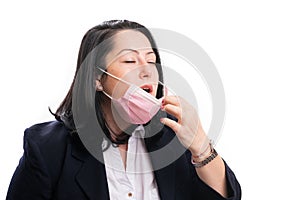Businesswoman taking off surgical or medical mask for sneeze