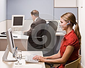 Businesswoman talking on headset at desk