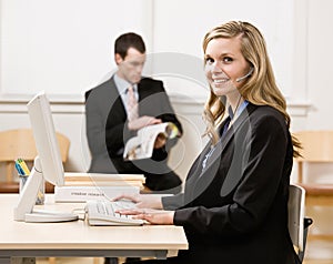 Businesswoman talking on headset at desk