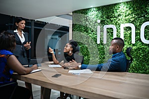 Businesswoman talking with her staff during a boardroom meeting