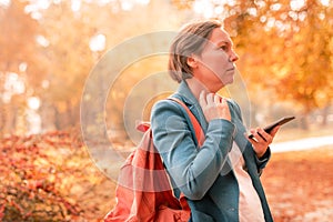 Businesswoman talking on mobile phone in autumn park