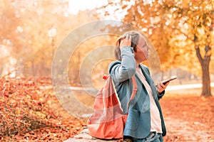 Businesswoman talking on mobile phone in autumn park