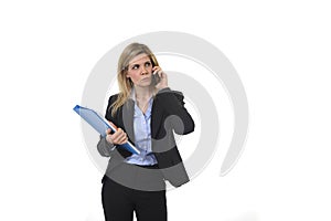Businesswoman talking on mobile phone holding office folder and pen looking busy and worried