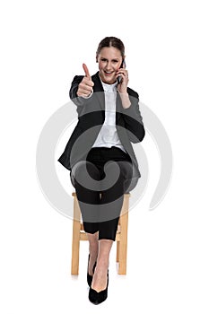 Businesswoman talking on phone and making a ok sign