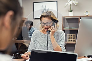 Businesswoman talking on phone at office