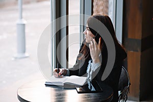 businesswoman talking on the phone and taking notes